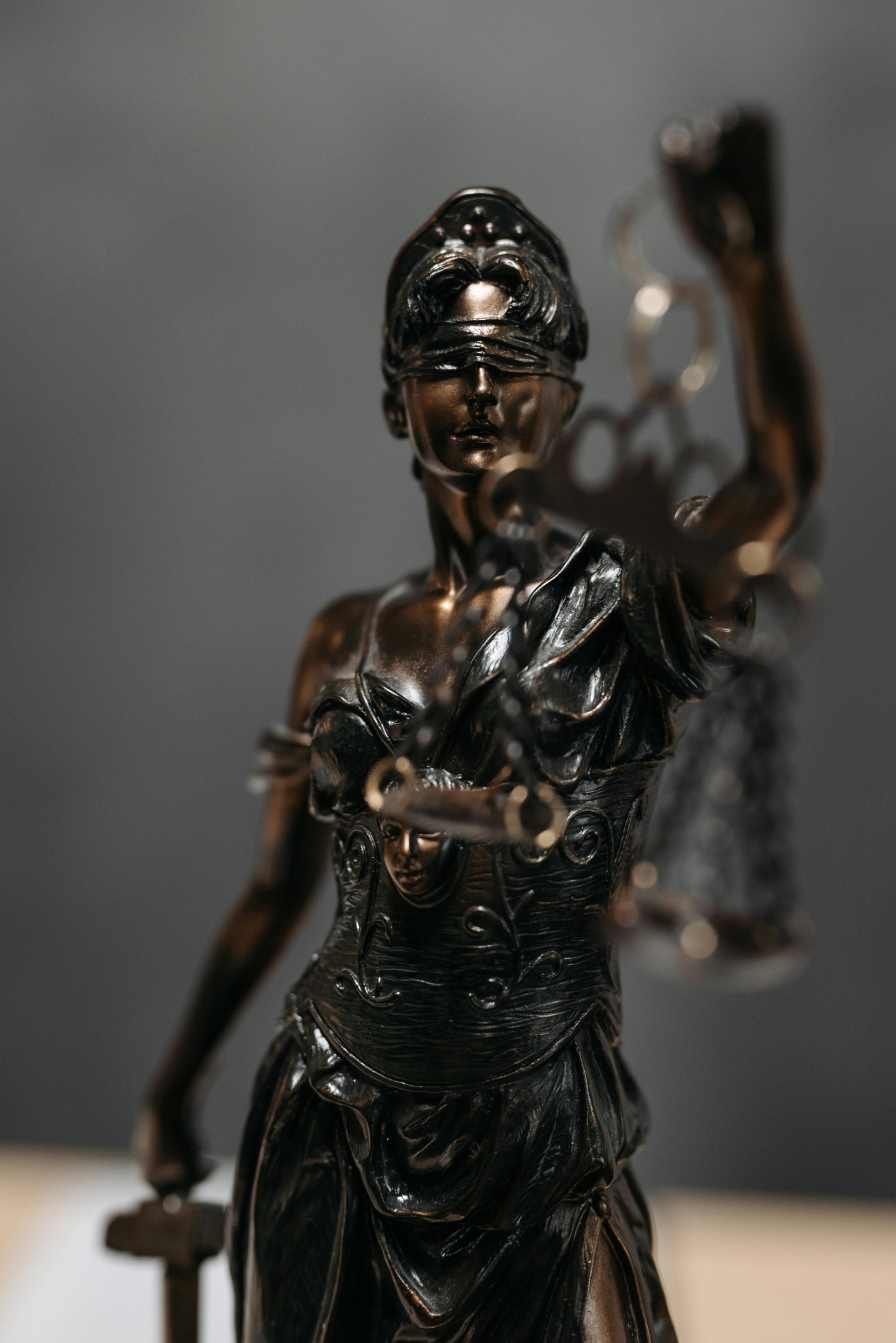 Detaillierte Bronzestatue der Justitia mit Waage, Symbol für Recht und Gerechtigkeit.